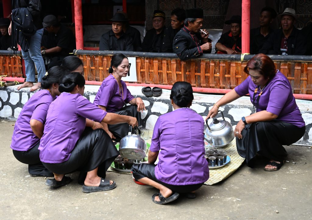 women serving coffee guests Rambu Solo funeral Tana Toraja Indonesia
