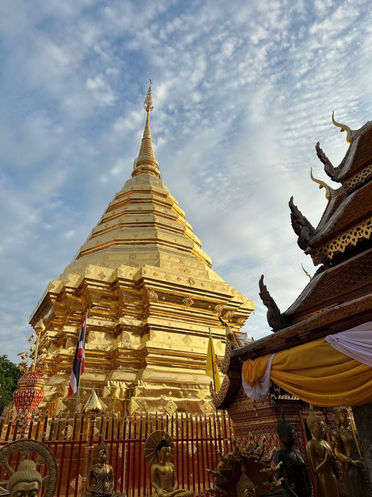 The massive golden chedi of Wat Phra That Doi Suthep against a morning sky in Chiang Mai.